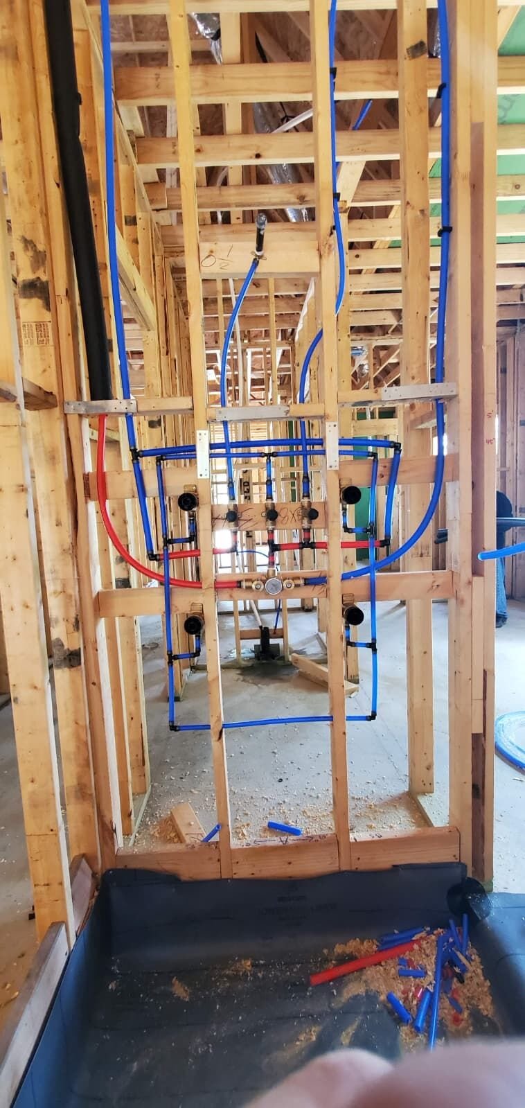 Red and blue PEX water lines routed through wall framing